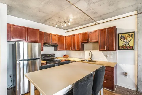 a kitchen with stainless steel appliances a refrigerator a sink a stove a microwave and wooden cabinets