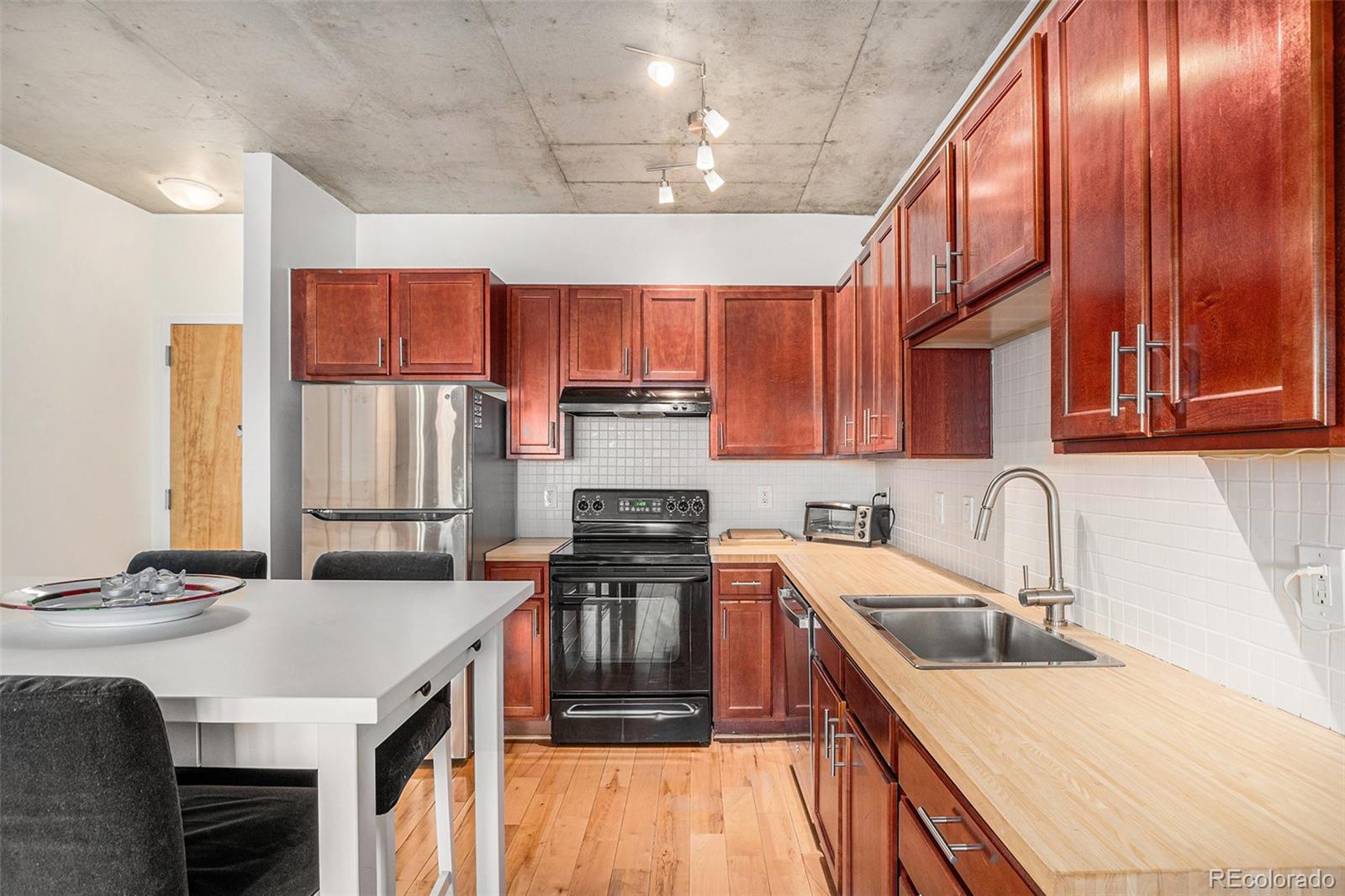 1475 Delgany Street, Unit 304 Denver, CO 80202 - Photo 9 of 28 a kitchen with stainless steel appliances granite countertop a sink stove and refrigerator