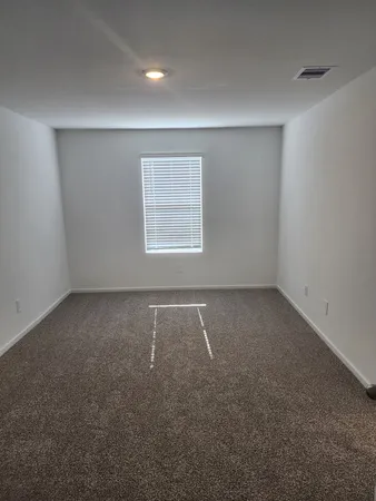 an empty room with a chair and a window