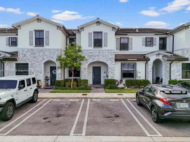 a front view of a house with yard and parking