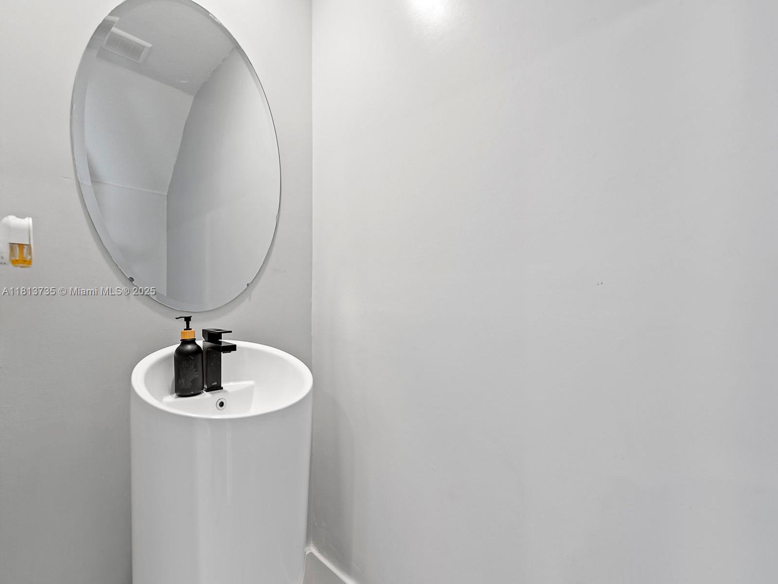 18058 Southwest 147th Court Miami, FL 33187 - Photo 9 of 27 a bathroom with a sink and a mirror