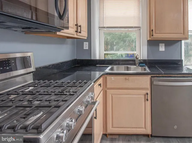 a kitchen with granite countertop a stove and a sink