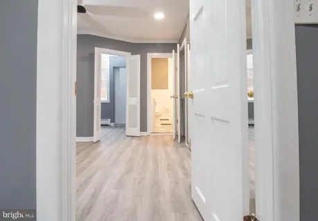 a view of an empty room with wooden floor & closet