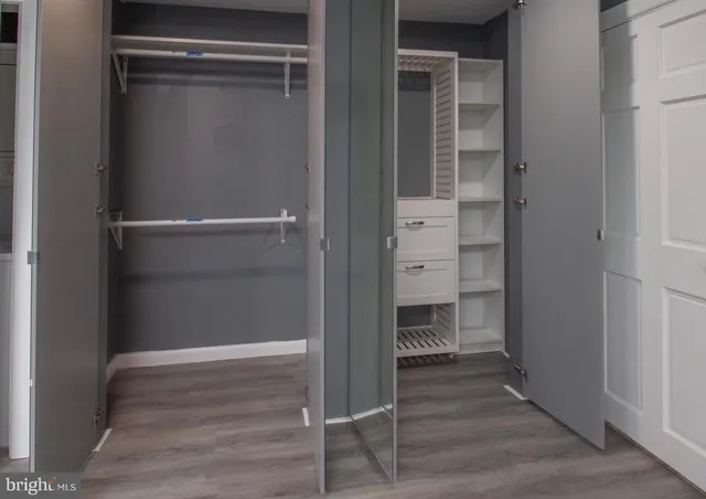 a view of an empty room with wooden floor & closet