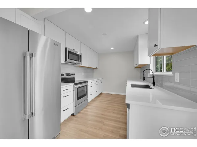 a kitchen with kitchen island a sink stainless steel appliances and cabinets