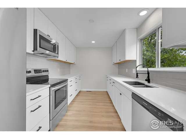 a kitchen with stainless steel appliances granite countertop a sink dishwasher a stove and a microwave oven with cabinets