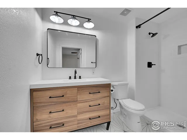 a bathroom with a toilet a sink a vanity and mirror