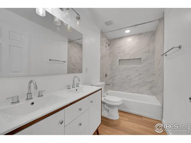 a bathroom with a double vanity sink toilet and shower