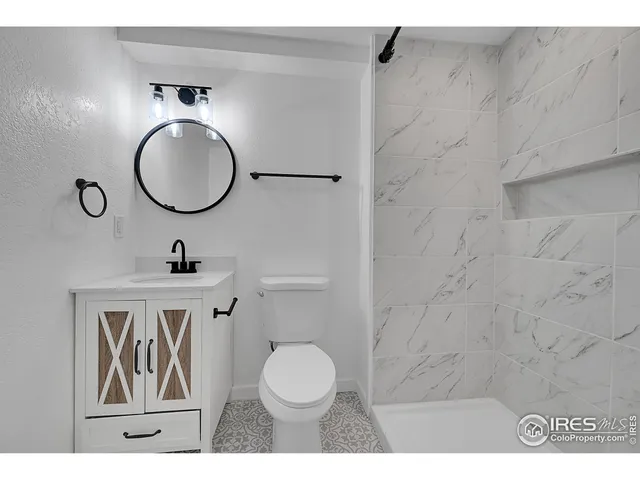 a bathroom with a toilet a sink and mirror