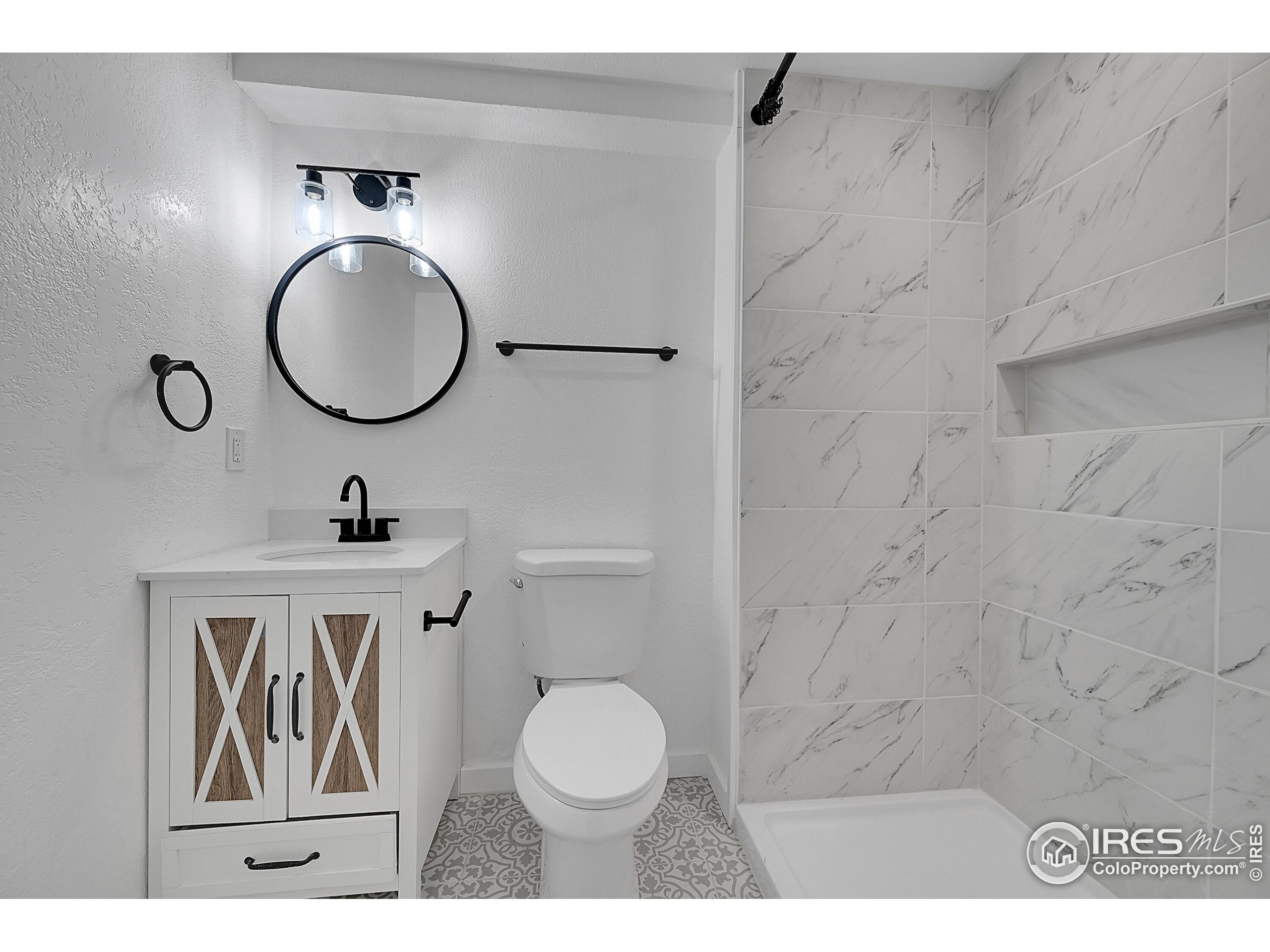 1836 Rice Street Longmont, CO 80501 - Photo 30 of 46 a bathroom with a toilet a sink and mirror