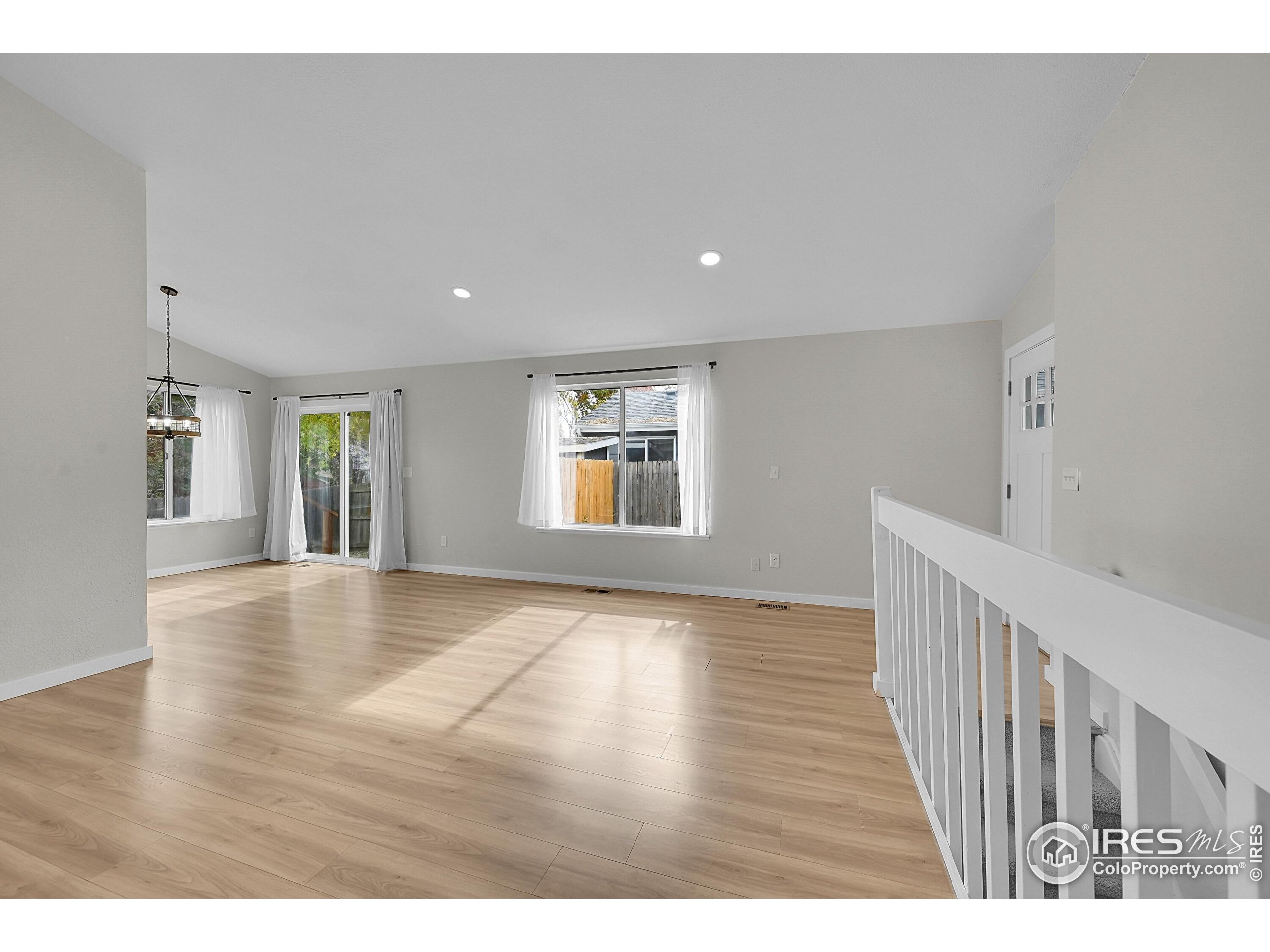 1836 Rice Street Longmont, CO 80501 - Photo 7 of 46 a view of an empty room with window and wooden floor