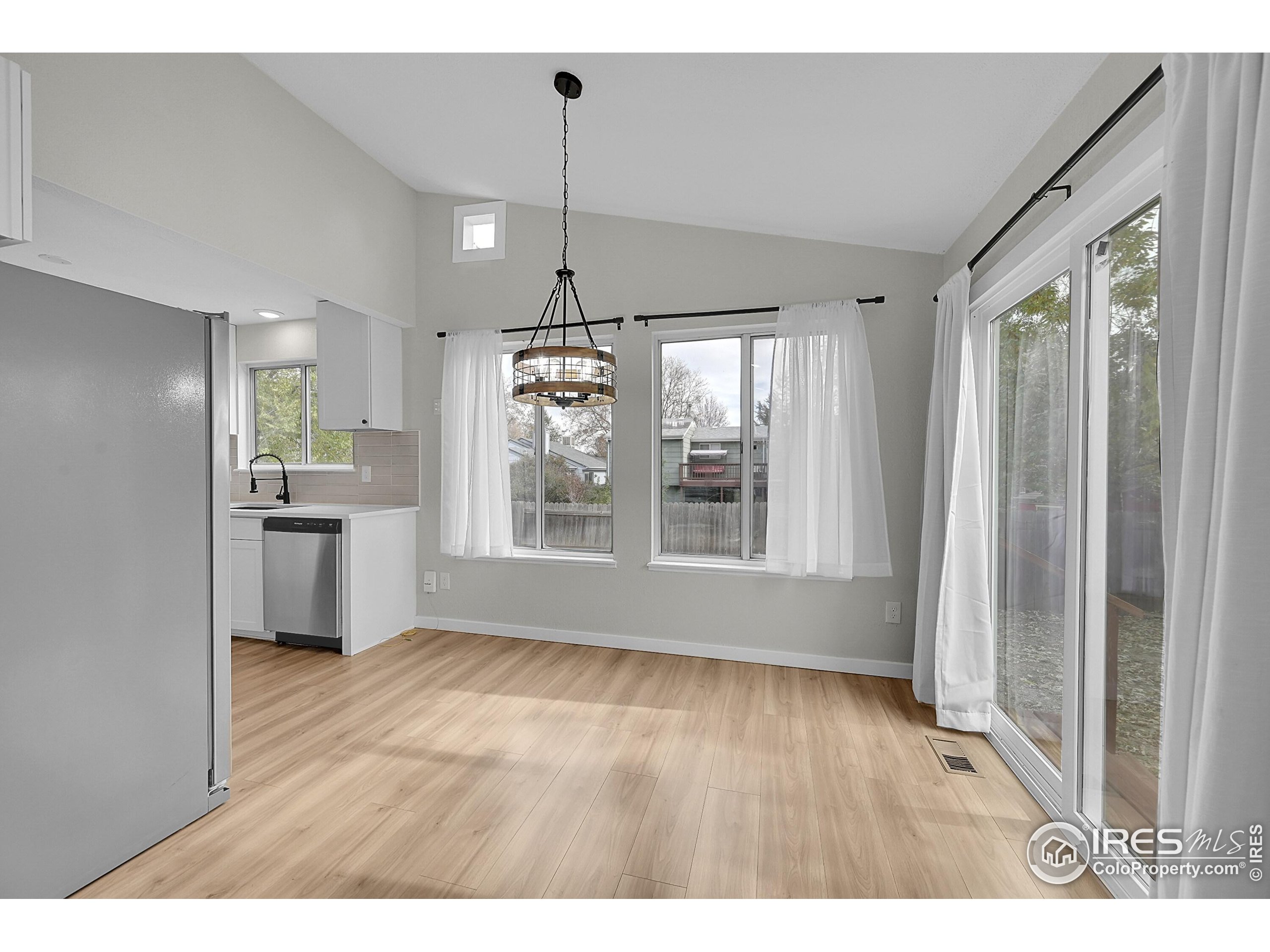 1836 Rice Street Longmont, CO 80501 - Photo 9 of 46 a view of an empty room with wooden floor kitchen view and a window