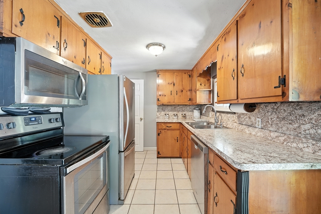 122 Drexel Street Springfield, MA 01104 - Photo 11 of 34 a kitchen with granite countertop a sink a stove and cabinets