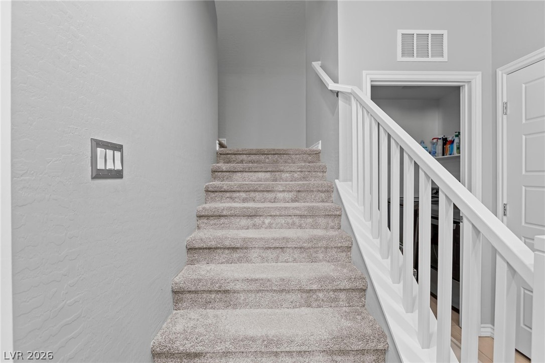 7310 North Decatur Boulevard, Unit 4 North Las Vegas, NV 89084 - Photo 9 of 35 Carpeted stairs ascend to a convenient second-story laundry area.