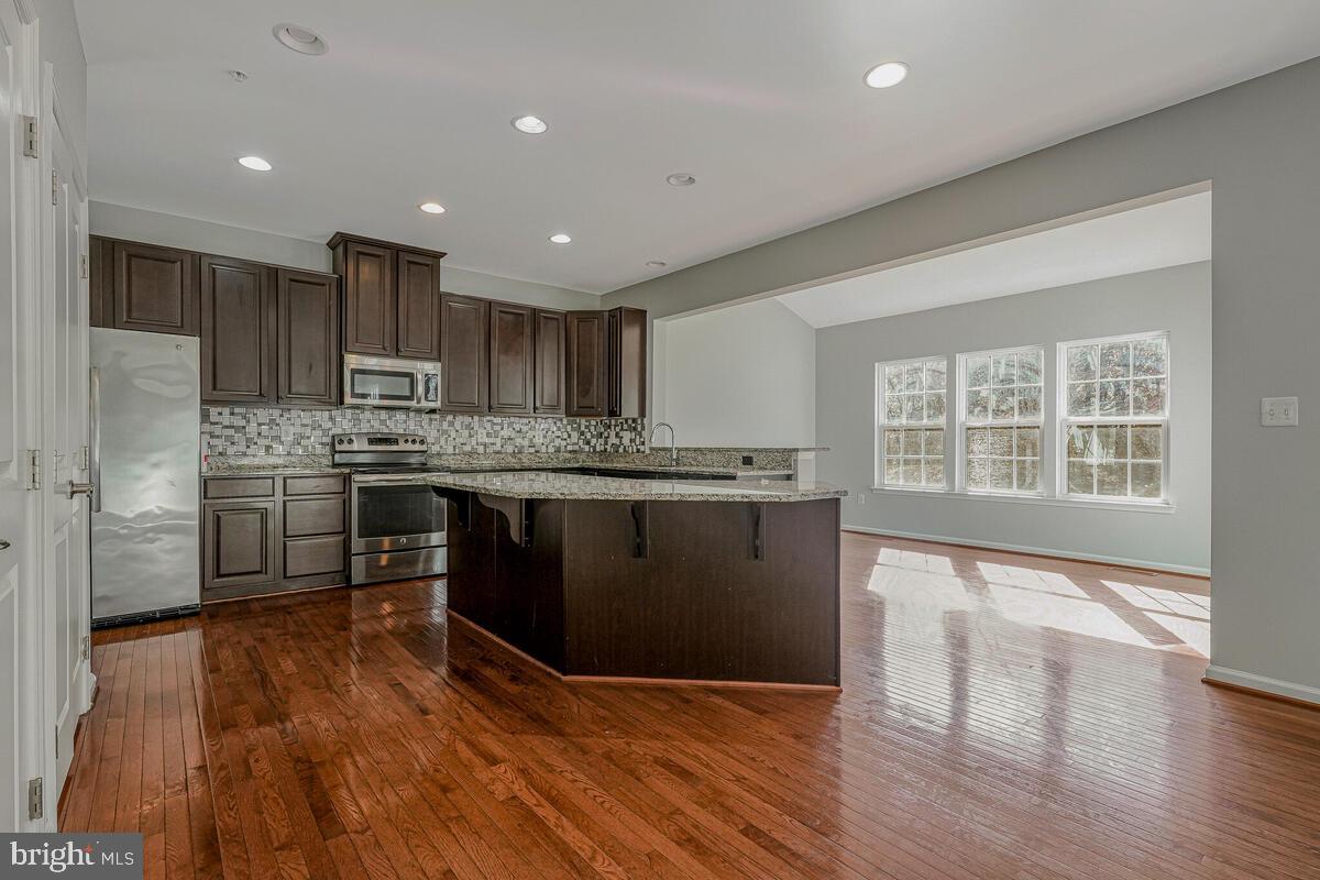 6911 Simmons Lane Clinton, MD 20735 - Photo 12 of 41 a kitchen with stainless steel appliances granite countertop a stove a sink and a refrigerator