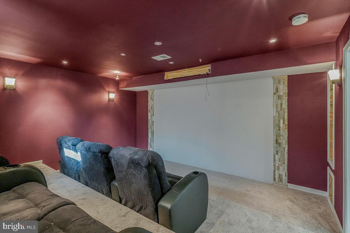 6911 Simmons Lane Clinton, MD 20735 - Photo 22 of 41 a media room with lots of chairs and a projector screen