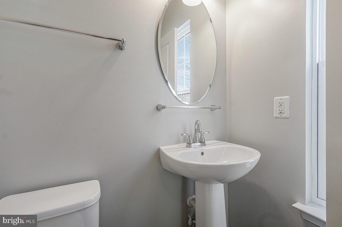 6911 Simmons Lane Clinton, MD 20735 - Photo 6 of 41 a bathroom with a sink a mirror and a toilet