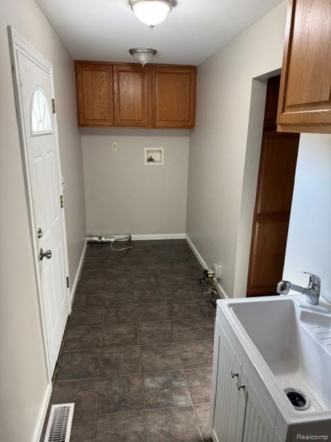 465 Trombley Road Troy, MI 48083 - Photo 18 of 24 Utility space featuring tile flooring, a utility sink with a base cabinet, upper wood-finish cabinetry, and a white paneled door