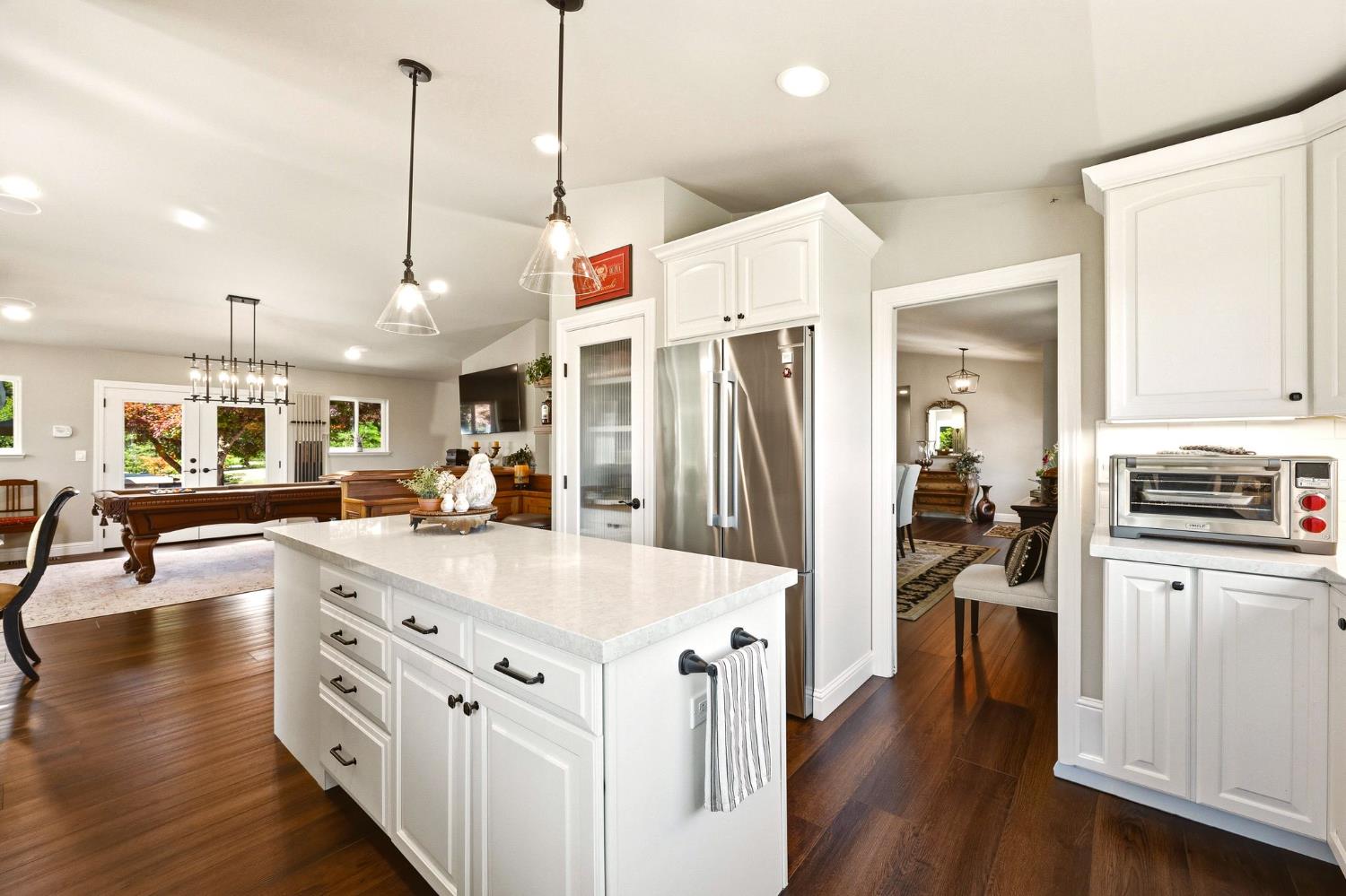 6380 Butterfield Way Placerville, CA 95667 - Photo 32 of 93 a kitchen with stainless steel appliances kitchen island granite countertop a refrigerator a oven a sink and white cabinets with wooden floor