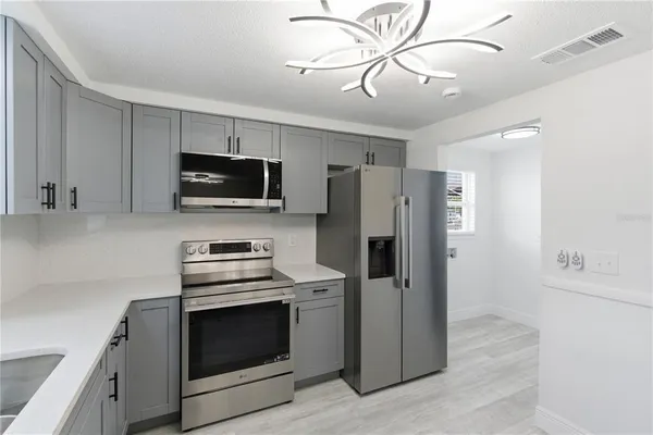 a kitchen with stainless steel appliances a stove microwave and refrigerator