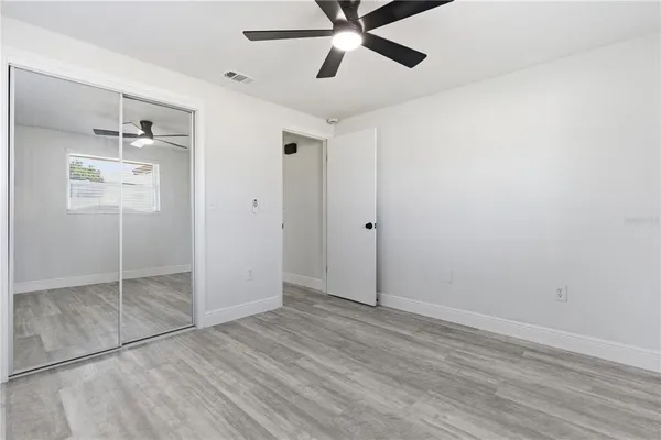 a view of empty room with wooden floor