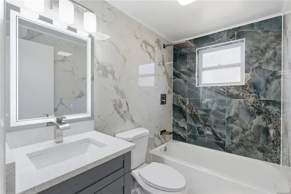 a bathroom with a sink toilet tub and shower