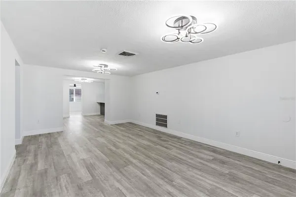 a view of empty room with wooden floor