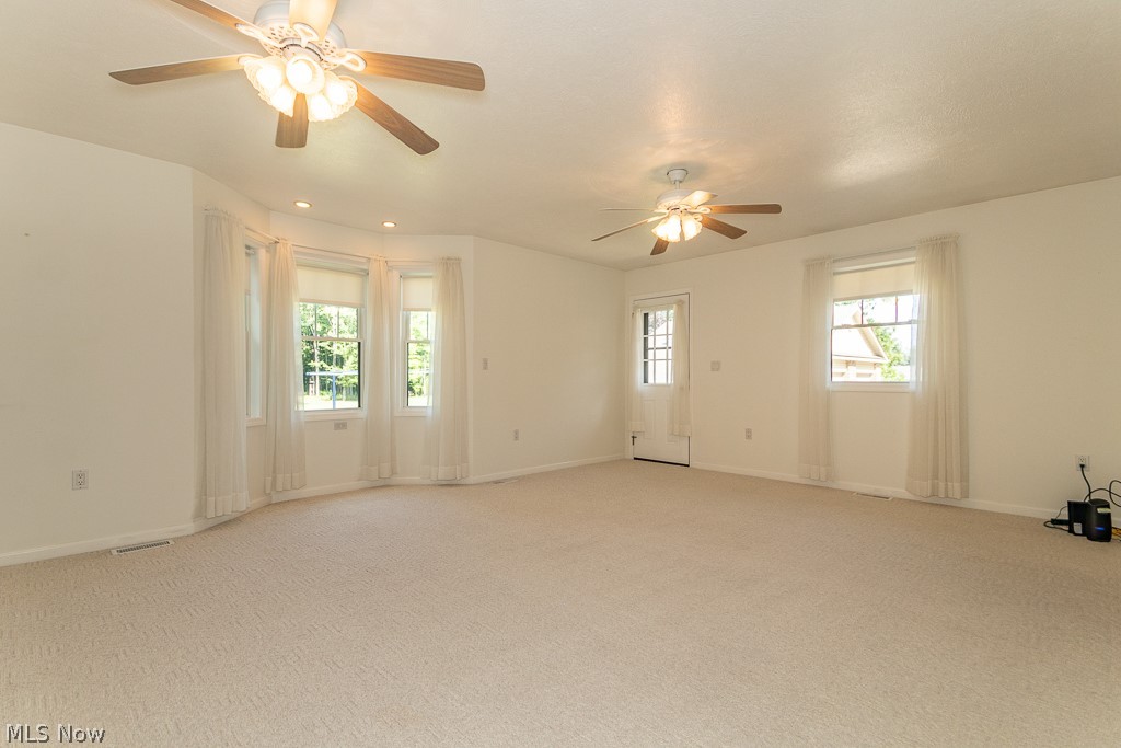 7710 Brakeman Road Painesville, OH 44077 - Photo 16 of 34 Carpeted empty room with ceiling fan and a healthy amount of sunlight