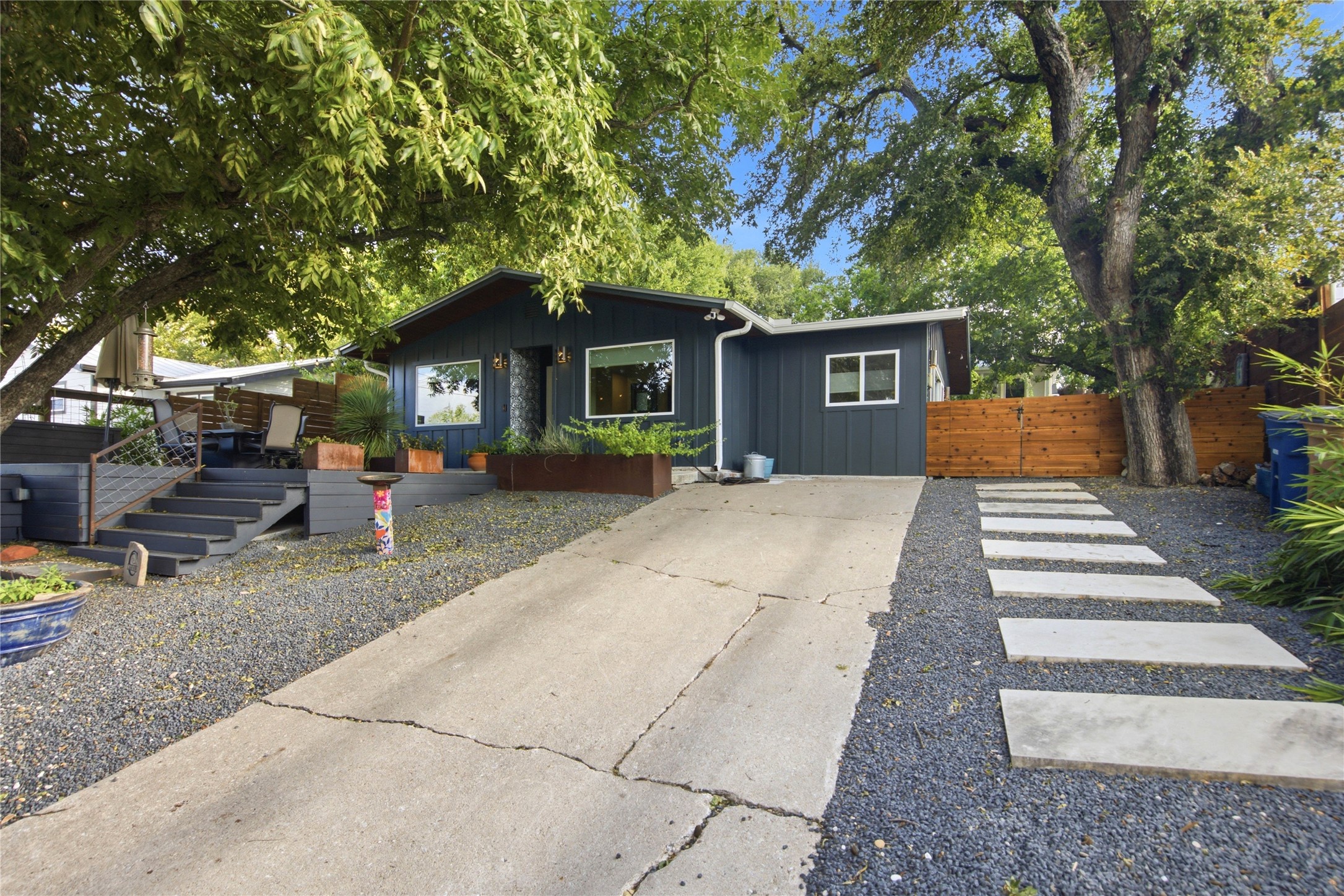 5600 Ledesma Road Austin, TX 78721 - Photo 20 of 36 Mature trees shade a welcoming front facade complete with a concrete driveway and modern walkways.