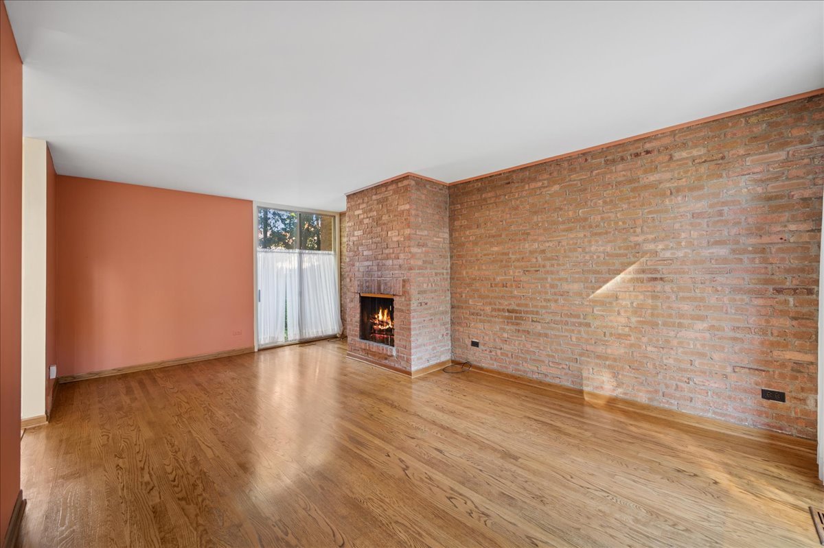 471 Linden Street Winnetka, IL 60093 - Photo 29 of 36 a view of an empty room with wooden floor and a fireplace
