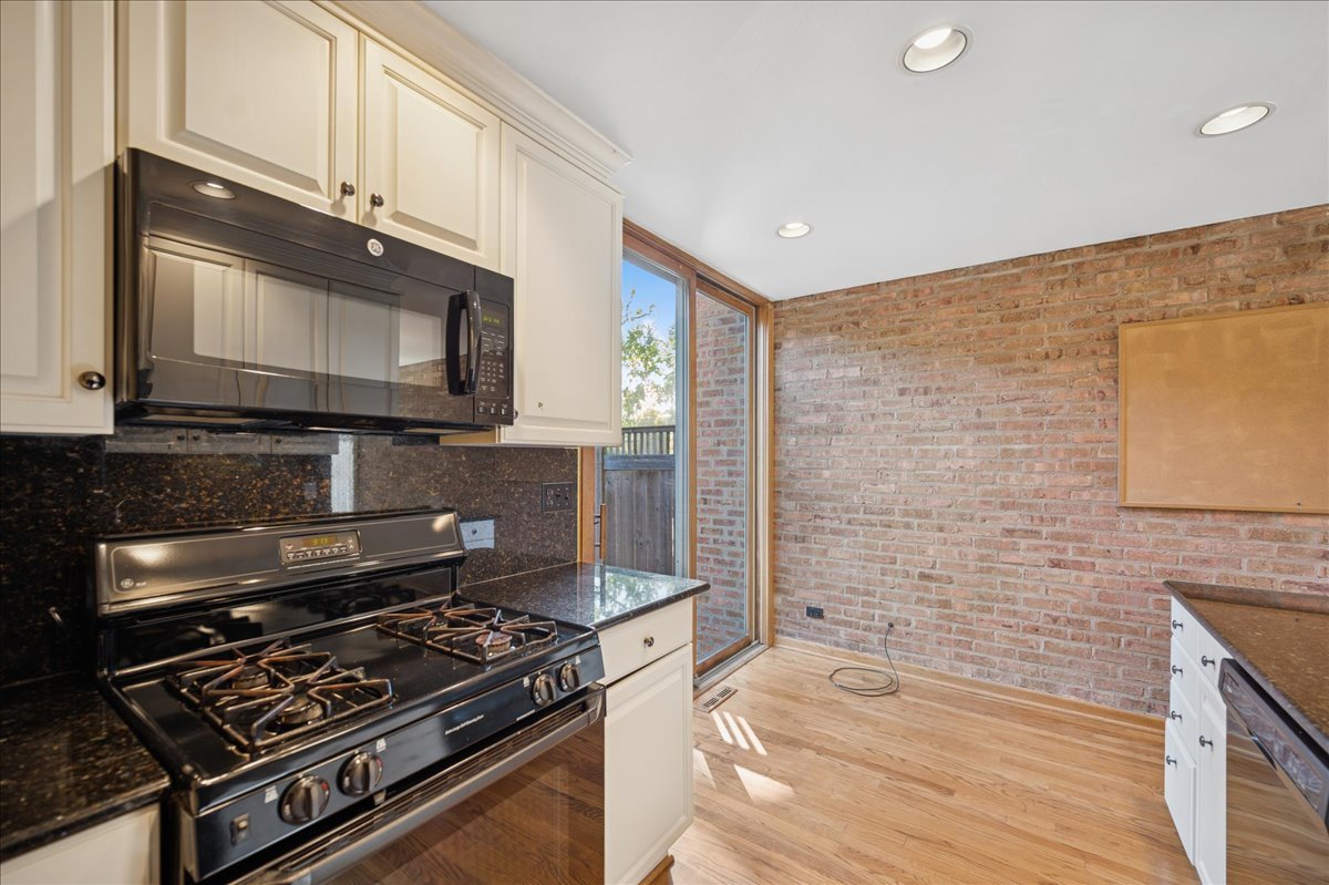 471 Linden Street Winnetka, IL 60093 - Photo 7 of 36 a kitchen with stainless steel appliances granite countertop a stove and a microwave