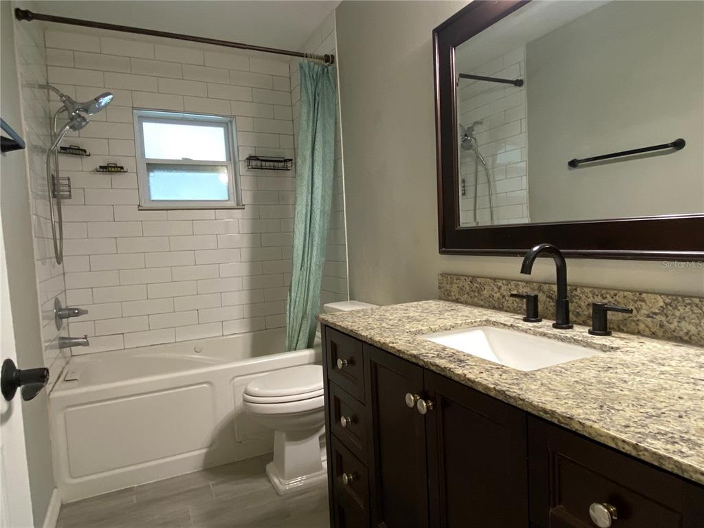 39656 Meadowood Loop Zephyrhills, FL 33542 - Photo 16 of 30 a bathroom with a granite countertop sink toilet and shower