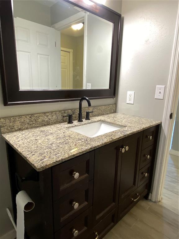 39656 Meadowood Loop Zephyrhills, FL 33542 - Photo 18 of 30 a bathroom with a granite countertop sink and a mirror
