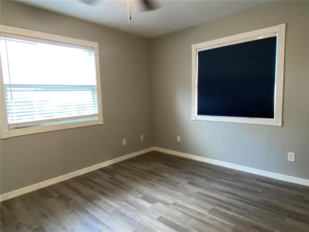 39656 Meadowood Loop Zephyrhills, FL 33542 - Photo 21 of 30 an empty room with wooden floor and windows