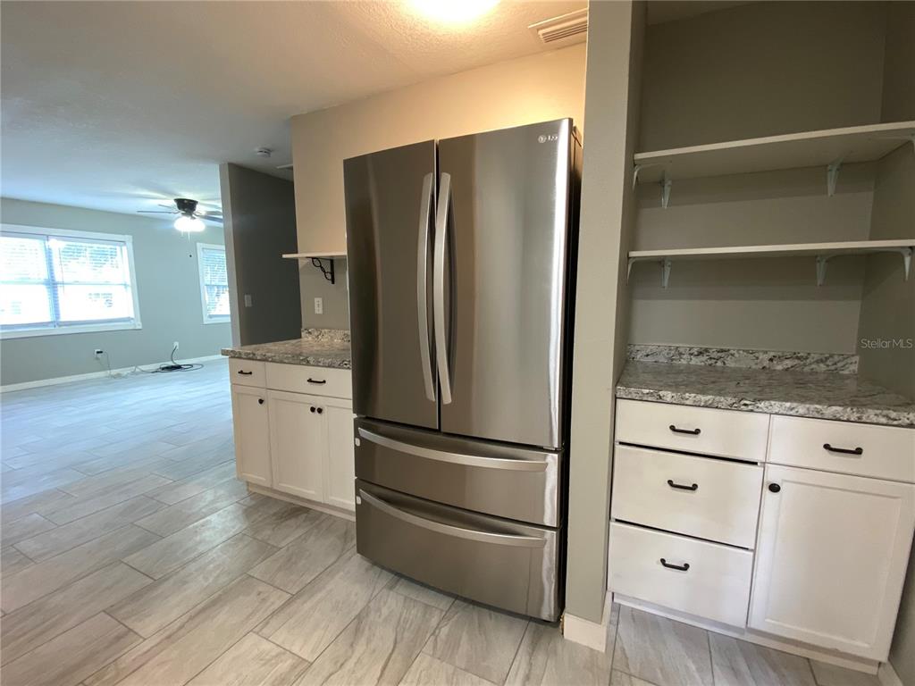 39656 Meadowood Loop Zephyrhills, FL 33542 - Photo 9 of 30 a kitchen with stainless steel appliances a refrigerator and a stove top oven