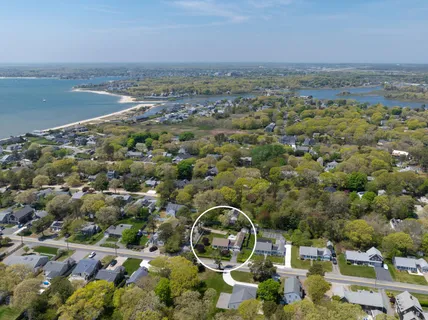 an aerial view of a residential houses with outdoor space and ocean view
