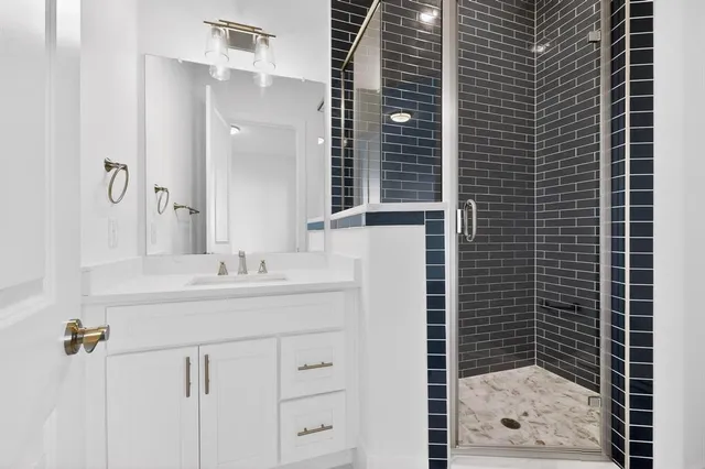 a bathroom with a shower sink and mirror