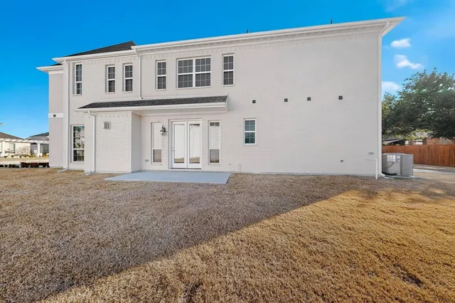a view of a house with backyard and trees