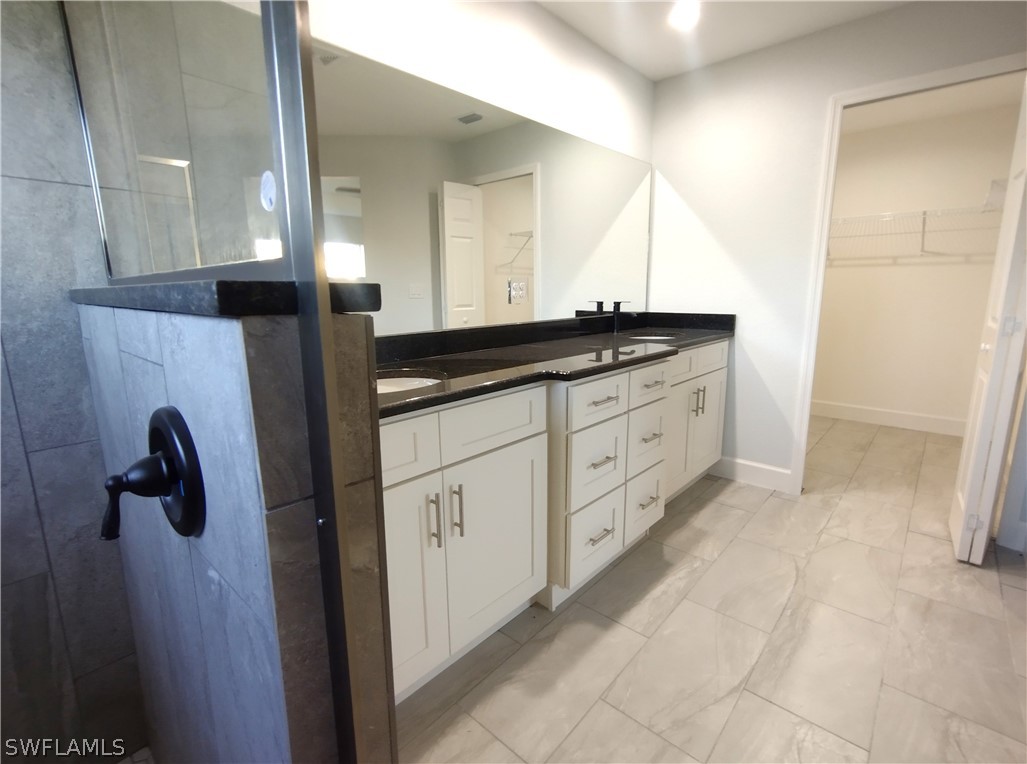 527 David Circle LaBelle, FL 33935 - Photo 19 of 35 a bathroom with a granite countertop sink a mirror and a shower