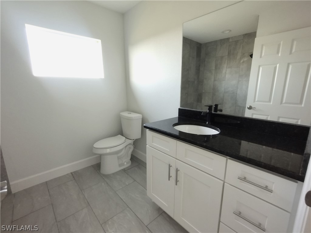 527 David Circle LaBelle, FL 33935 - Photo 26 of 35 a bathroom with a granite countertop sink a toilet and a mirror