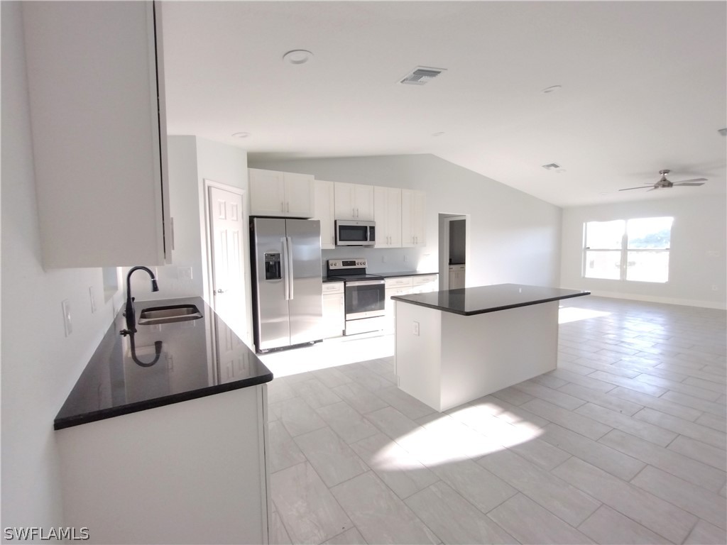 527 David Circle LaBelle, FL 33935 - Photo 3 of 35 a large white kitchen with kitchen island a sink a stove a refrigerator and white cabinets