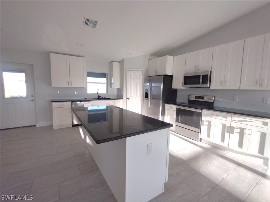 527 David Circle LaBelle, FL 33935 - Photo 4 of 35 a kitchen with stainless steel appliances granite countertop a sink stove and microwave