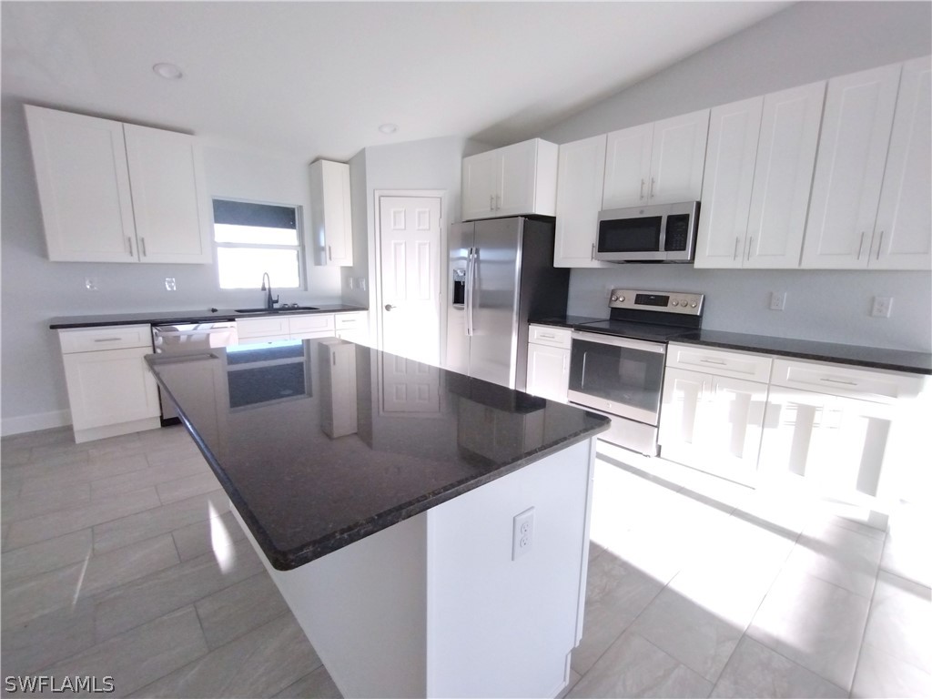 527 David Circle LaBelle, FL 33935 - Photo 6 of 35 a kitchen with stainless steel appliances granite countertop a sink a stove top oven a counter space and cabinets