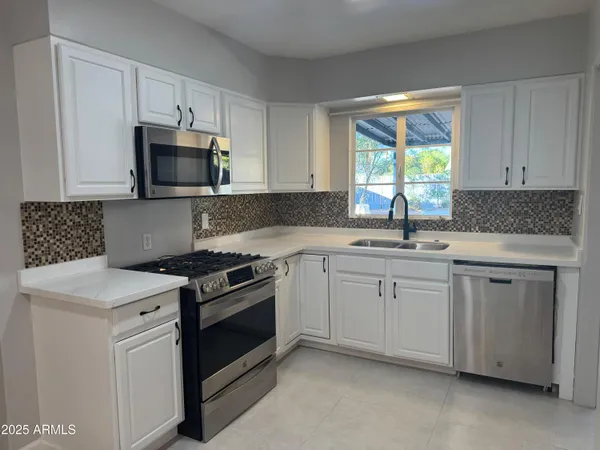 a view of kitchen with refrigerator stove and wooden floor