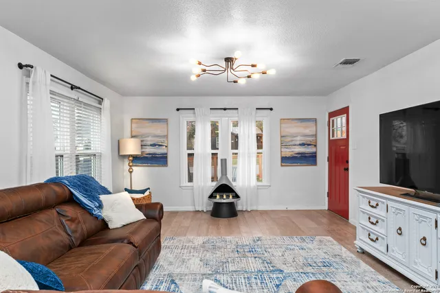 a living room with furniture a chandelier and a flat screen tv