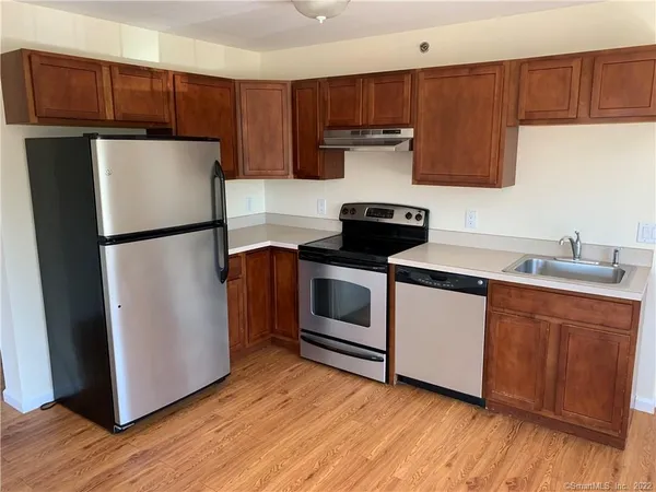 a kitchen with a refrigerator sink and cabinets