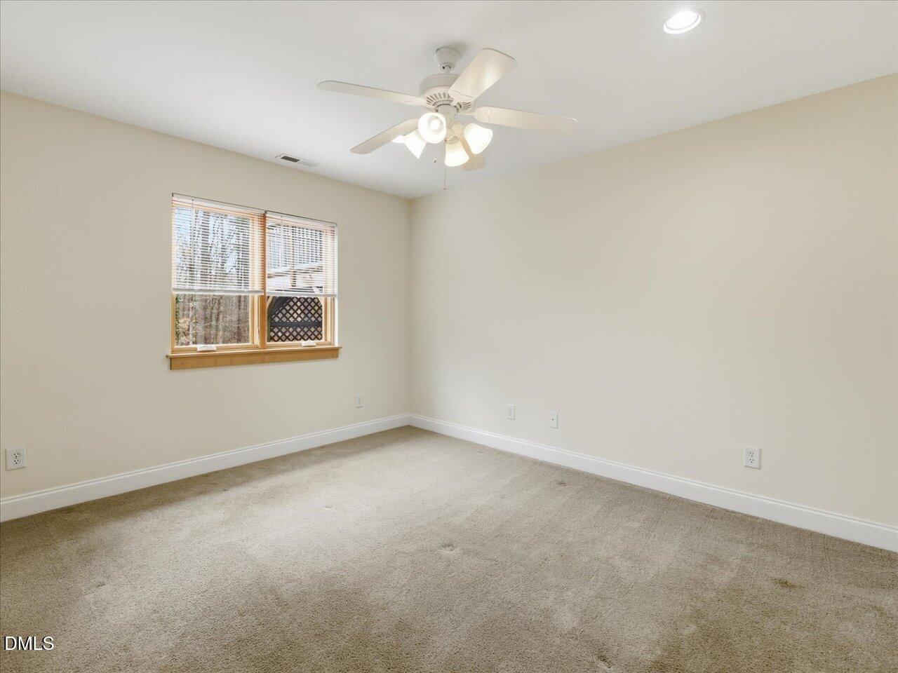 67 Bingham Ridge Drive Pittsboro, NC 27312 - Photo 54 of 82 an empty room with a chandelier fan and windows