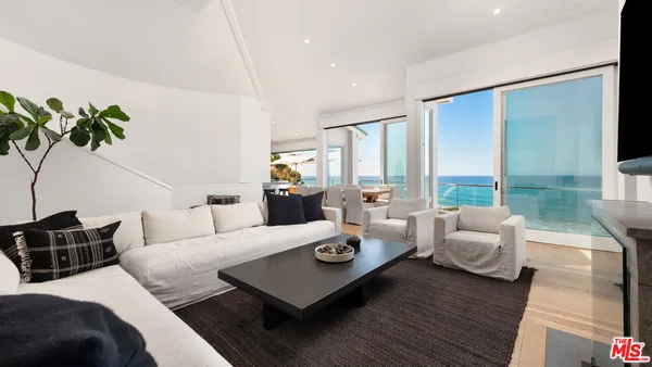 a living room with furniture and large windows