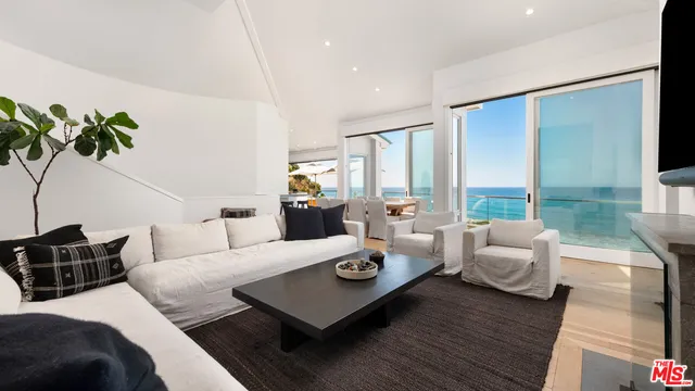 a living room with furniture and large windows