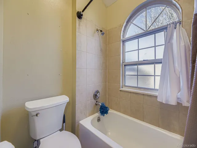 a white toilet sitting next to a bath tub